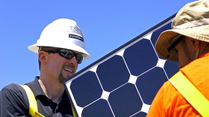 рабочие устанавливают солнечные панели