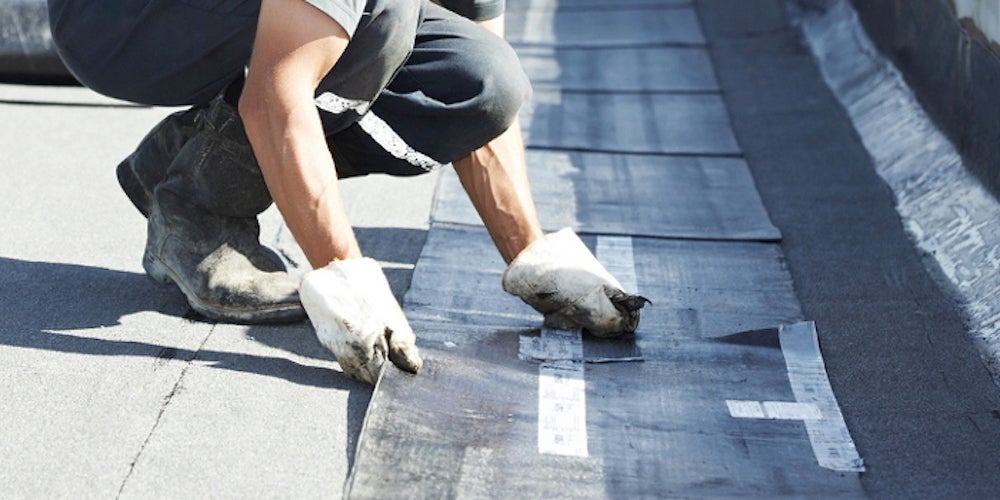 A homneowner attempting DIY flat roof repair