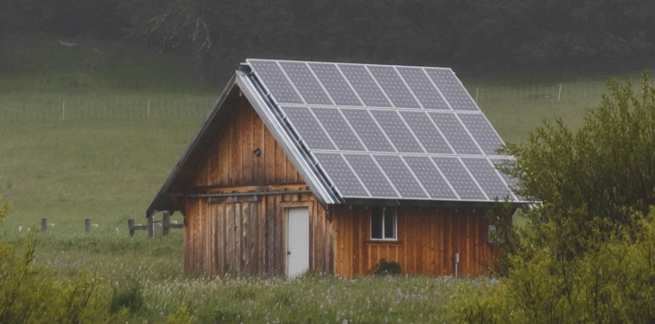 tiny home in the middle of a field with solar panels on its roof