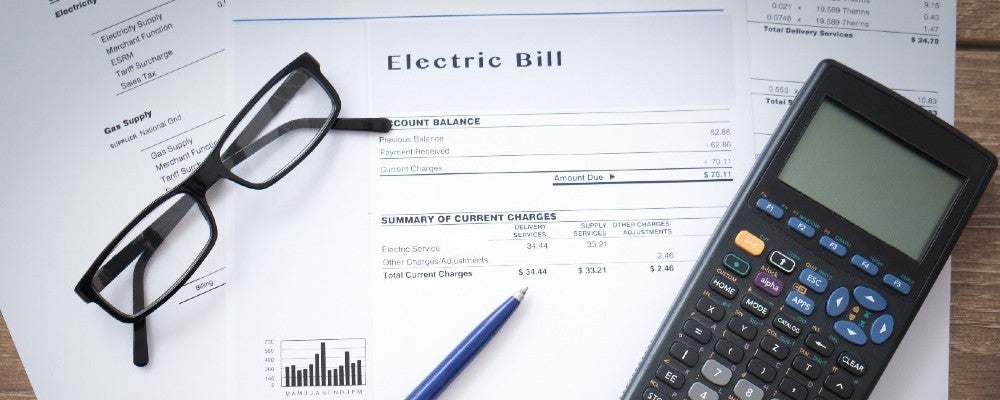 Electric bill and calculator on desk