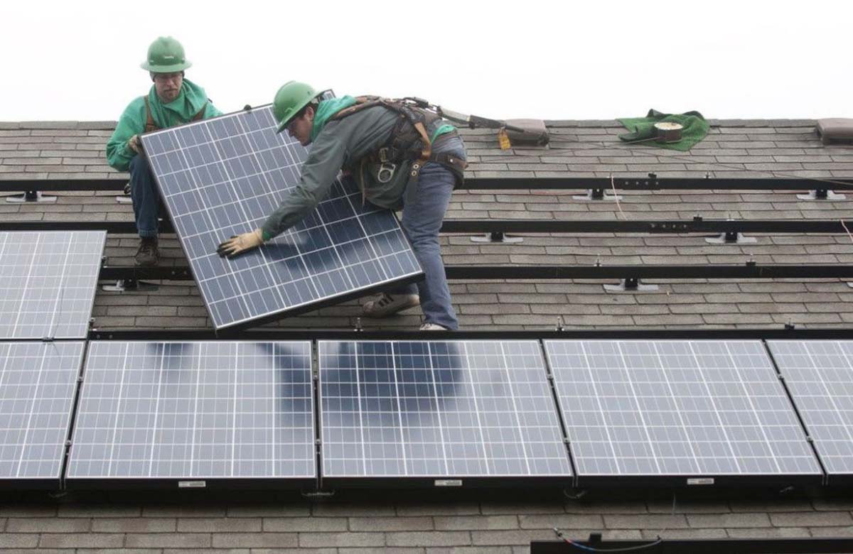 two installers on a roof with solar panels