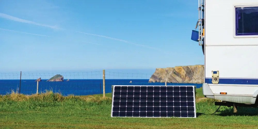 Solar panels next to an RV on a beach