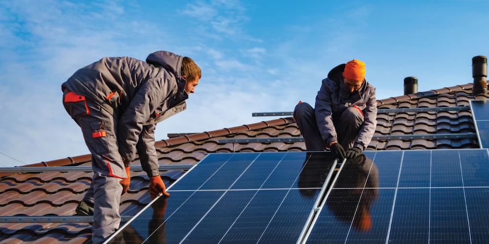 Solar panel experts working on installing panels on a roof